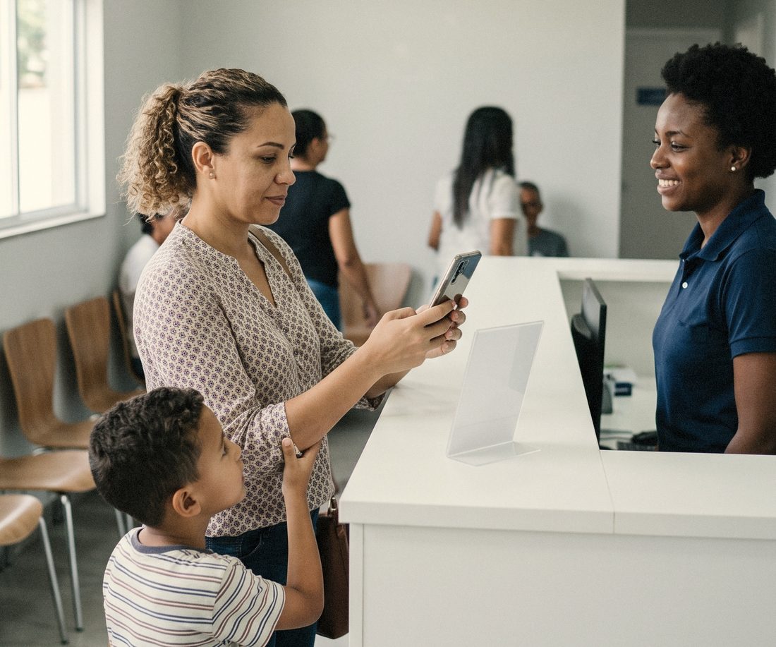 Mãe com o filho aponta o celular para o cartaz no balcão, ao lado da recepcionista